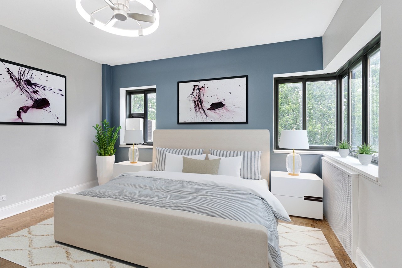 Bedroom with blue accent wall and bay windows