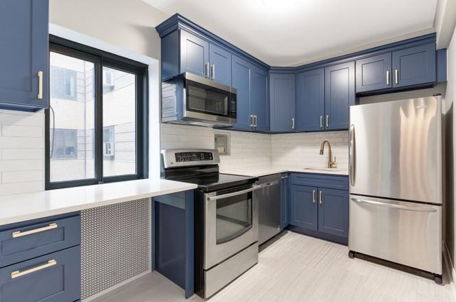 Condo kitchen with navy cabinets and stainless appliances