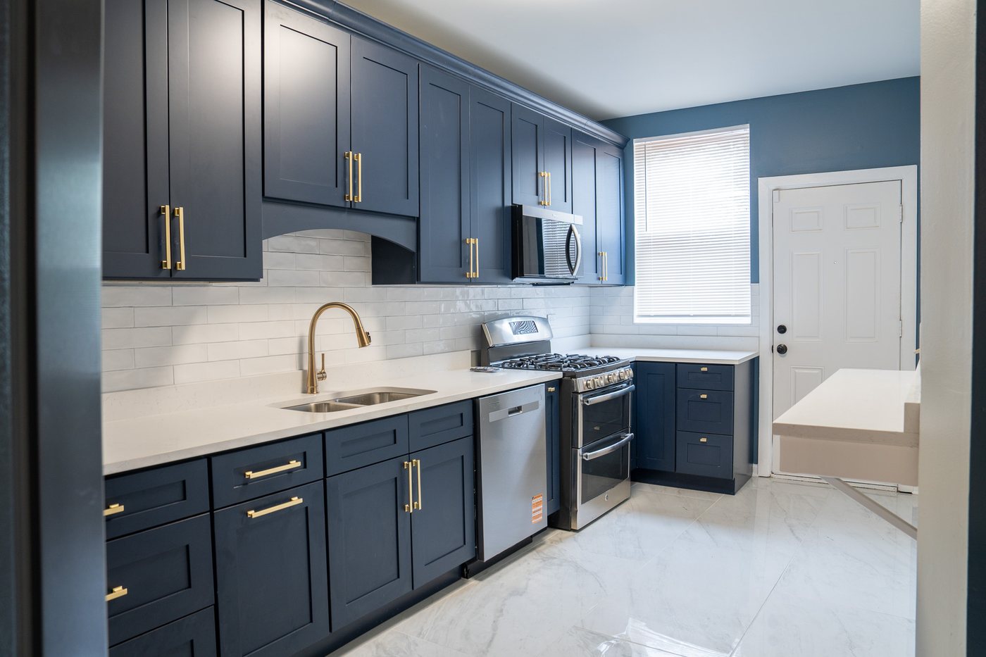 Kitchen with navy cabinets and quartz counters